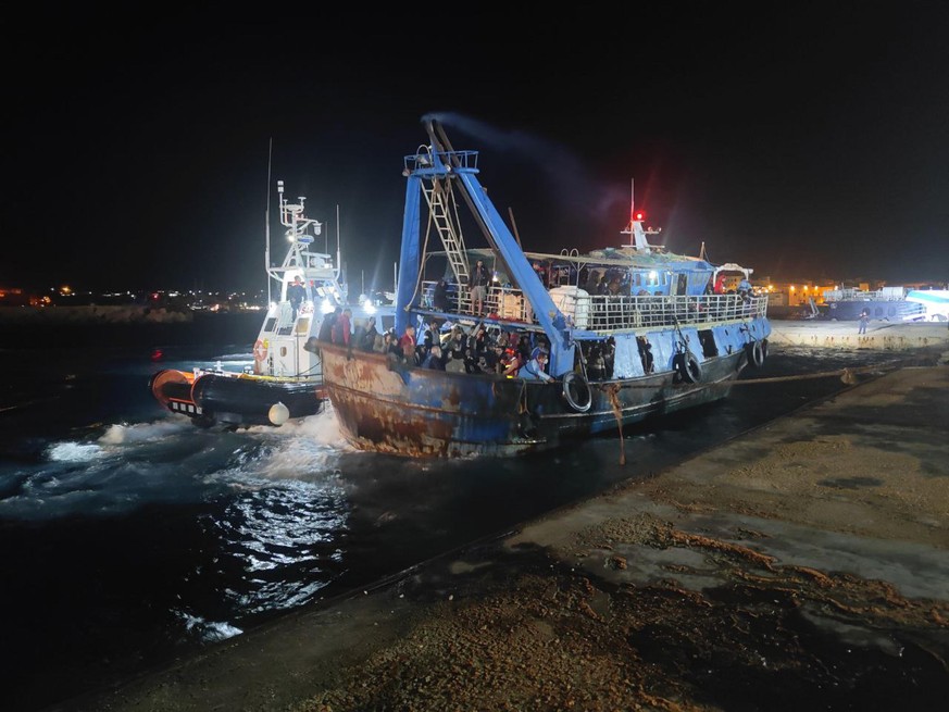 epa10986877 A fishing boat carrying around 400 migrants arrives at Lampedusa&#039;s commercial pier, following a shipwreck that left eight people missing and a child dead in Lampedusa, Sicily, Italy,  ...