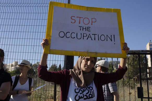 A Palestinian woman takes part in a protest against the forcible evictions of dozens of Palestinian families by Israeli settlers in the Sheikh Jarrah neighborhood of east Jerusalem, Friday, June 4, 20 ...