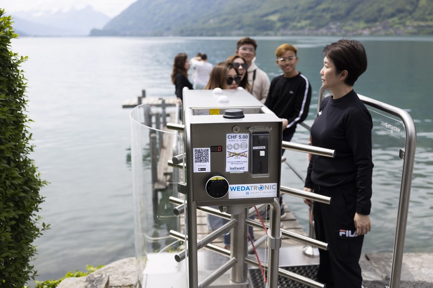 epa10643848 Korean visitors get on the pier after paying 5 Swiss Francs in Iseltwald, Switzerland, 21 May 2023. Lots of Asian TV fans and tourists visit the place because of the romantic Korean Netfli ...