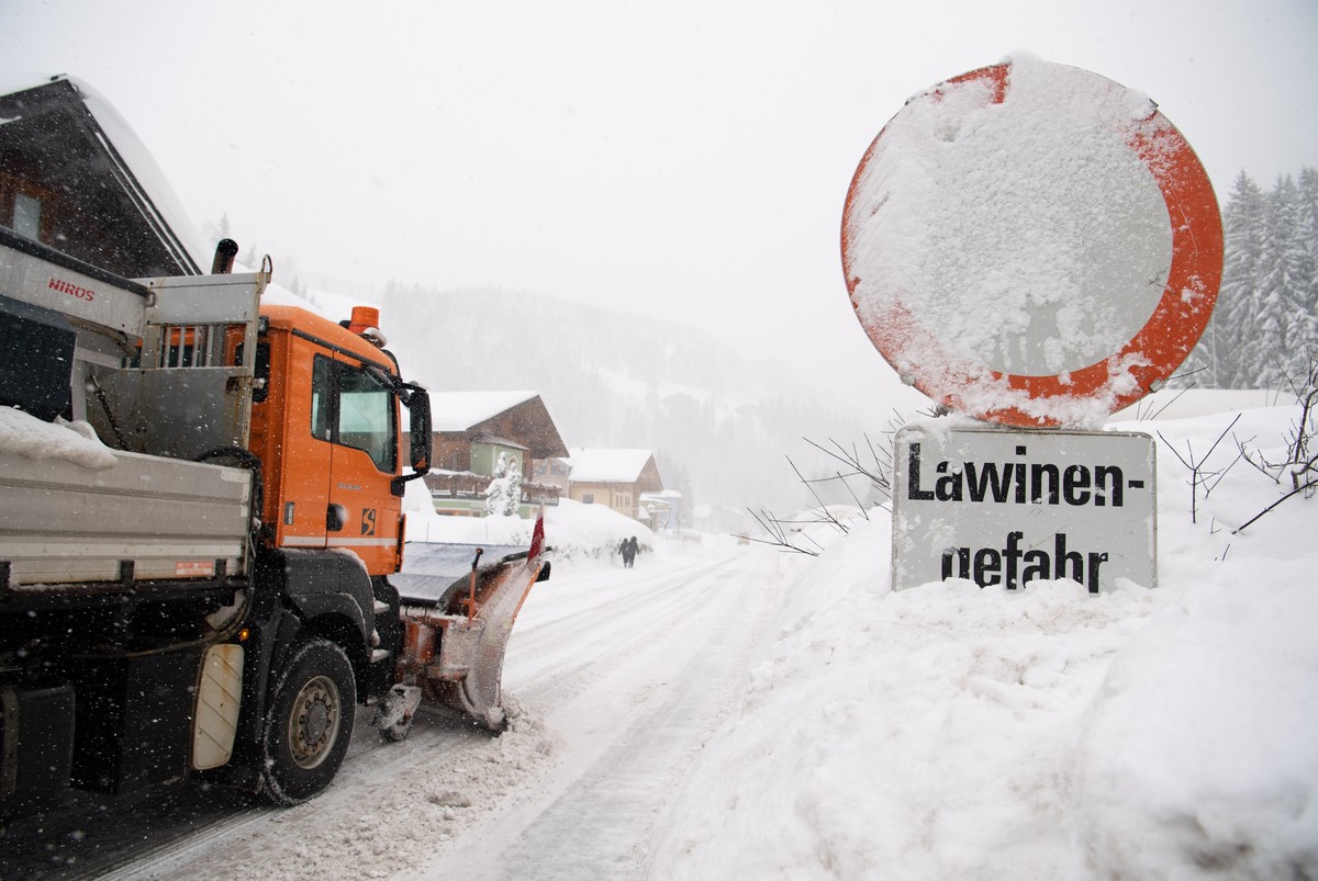 epa07269594 A snowploough passes a sign saying 'Avalanche Danger' on a road in Filzmoos, Austria, 08 January 2019. Media reports state that many regions in Austria, Germany, Switzerland and  ...