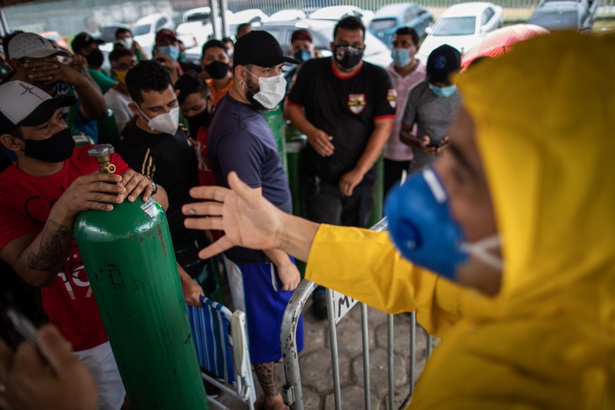 epa08949846 Relatives of patients infected with Covid-19 wait for hours since early in the morning to refill their oxygen cylinders at the Carboxi company, in Manaus, Amazonas, Brazil, on 19 January 2 ...