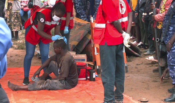 In this photo taken from video a man is helped by medical personal at a site of a collapsed landfill in Kampala, Uganda, Saturday, Aug. 10, 2024. At least 18 people were killed after a landfill collap ...
