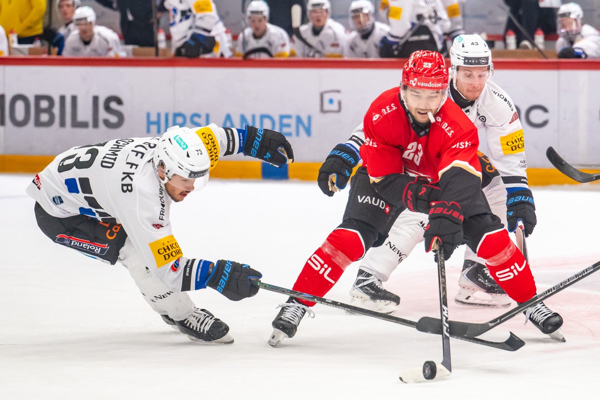 Sandro Schmid (HCFG), gauche, lutte pour le puck avec Philipp Kurashev (LHC) et Thierry Schild (HCFG), droite, lors du match de championnat suisse de hockey sur glace de National League, entre Lausann ...