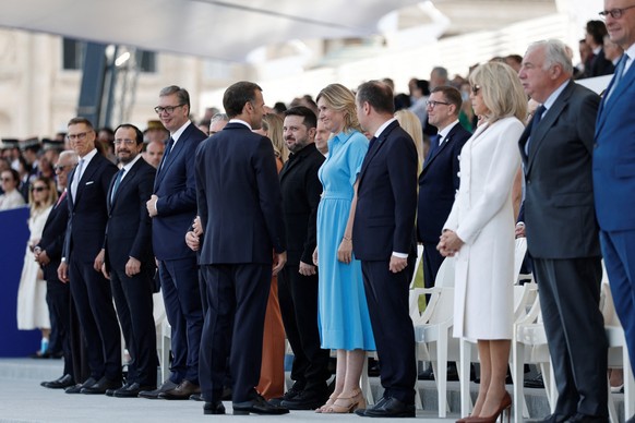 epa13110286 French President Emmanuel Macron (C-L) greets President of the National Assembly Yael Braun-Pivet (C-R) and guests as Ukraine's President Volodymyr Zelenskiy (C) looks on during the a ...
