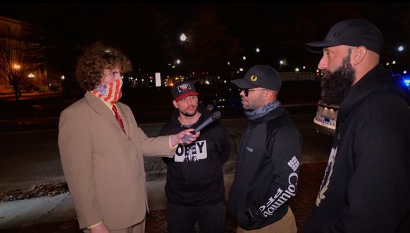 Andrew Callaghan in seiner typischen Aufmachung bei einem Interview.