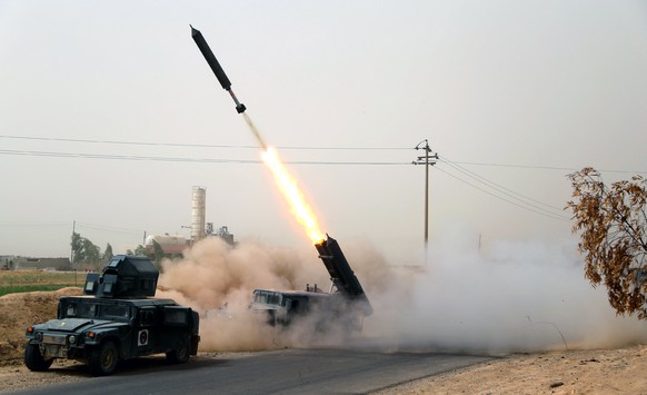 epa06222228 Members of Iraqi Shiite militia troops fire a missile against Islamic State (IS) position in Shirqat town, northern Iraq, 23 September 2017. Iraqi forces and pro-government militias have m ...