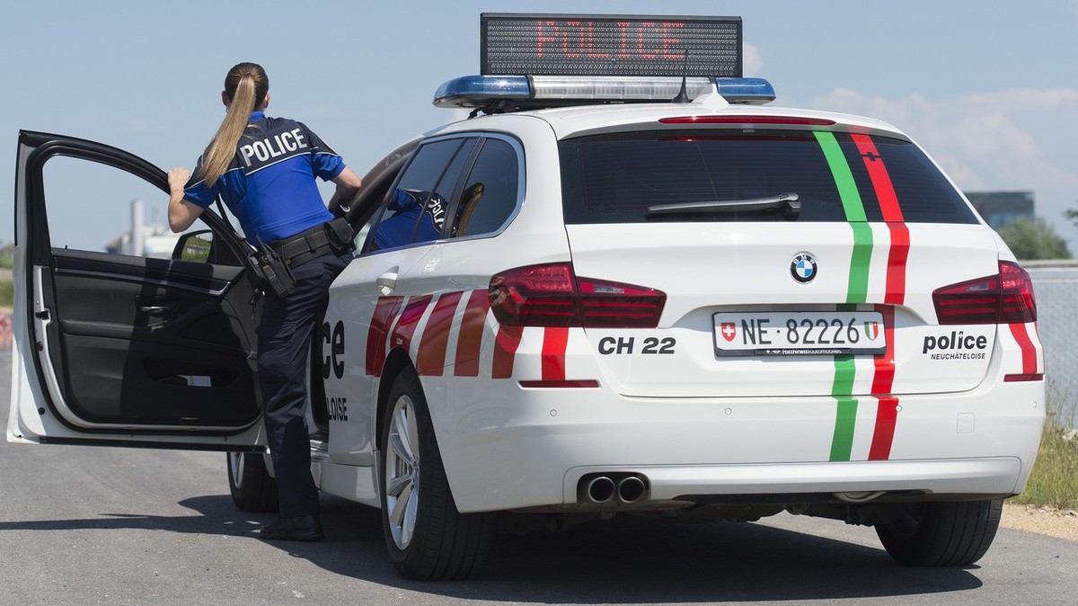 Une policiere de la Police cantonale neuchateloise photographies avec une voiture de police, le 5 juin 2015, a Neuchatel. (KEYSTONE/Sandro Campardo) 

Eine Polizistin der Kantonspolizei Neuenburg best ...