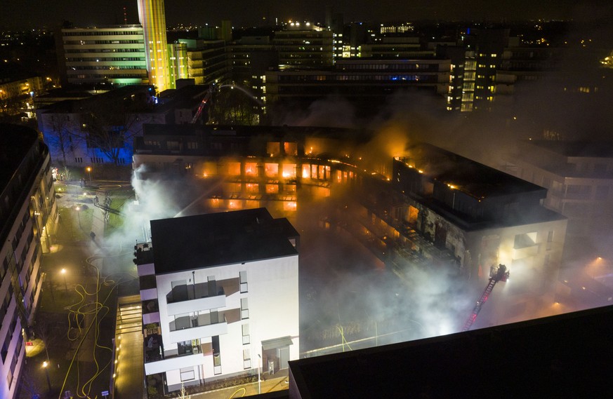 Firefighters battle a fire at residential complex in Essen Germany, Monday, Feb. 21, 2022. The fire service said that about 100 people were evacuated from the complex and about 150 officers were dispa ...