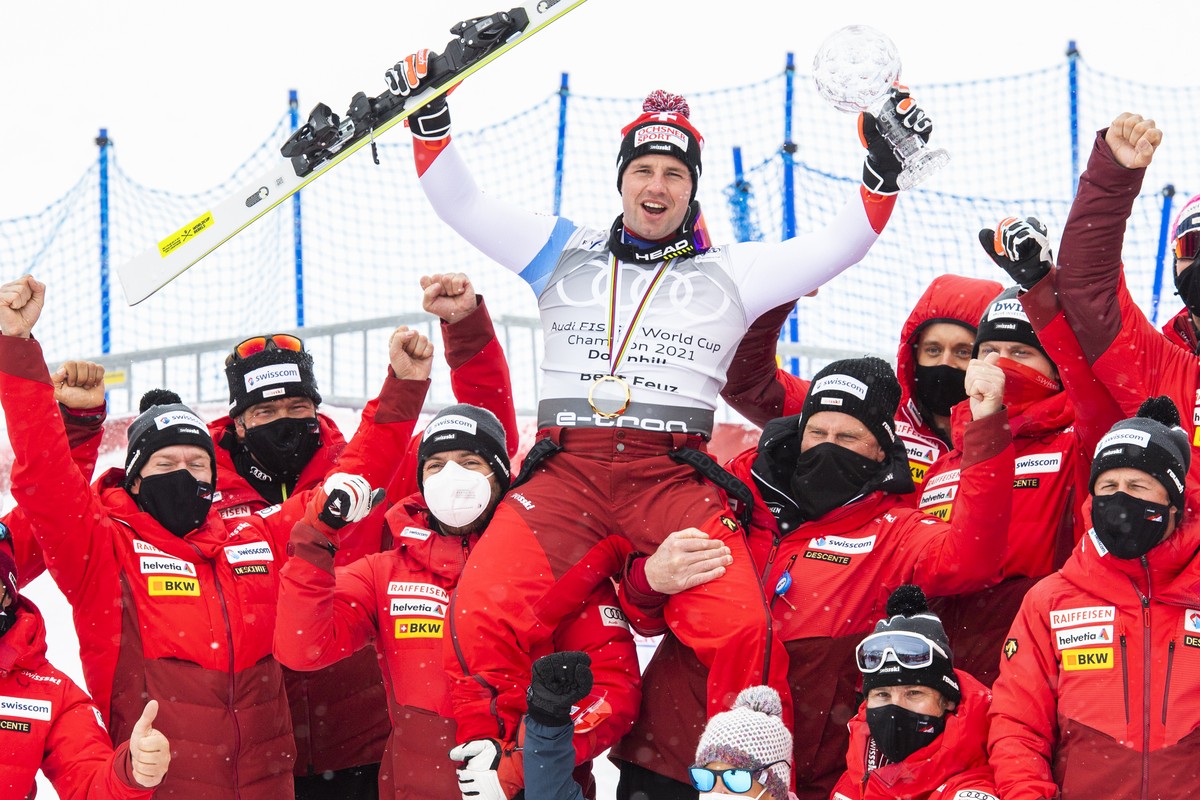Winner Beat Feuz of Switzerland and team celebrate with the crystal globe of the overall men's downhill competition during the podium at the FIS Alpine Skiing World Cup finals, in Parpan-Lenzerhe ...