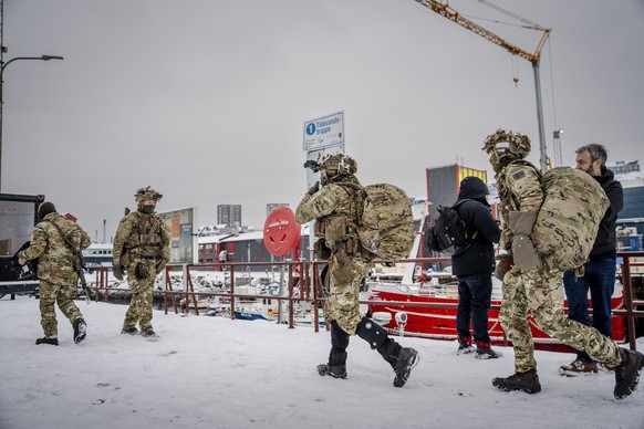 epa12659432 Danish soldiers leave the harbor after disembarking a boat at the port in Nuuk, Greenland, 18 January 2026. The Danish Defense will continue the increased presence with exercise activities ...