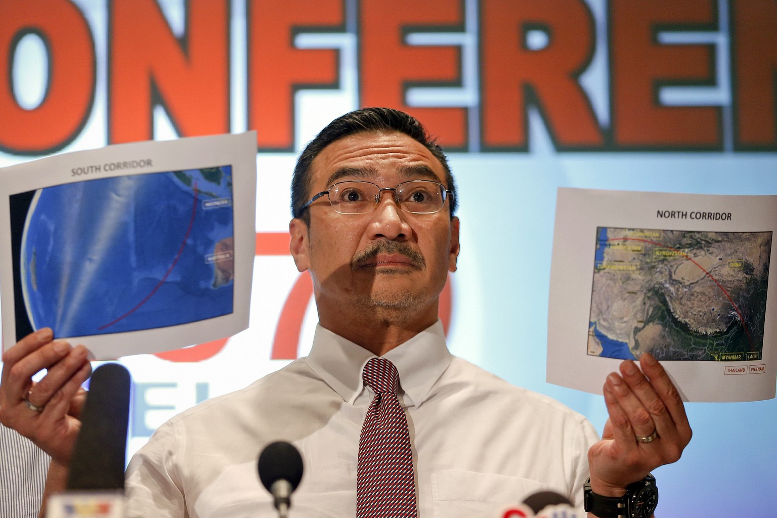 Malaysia&#039;s acting Transport Minister Hishammuddin Hussein shows two maps with corridors of the last known possible location of the missing Malaysia Airlines MH370 plane as he addresses reporters  ...