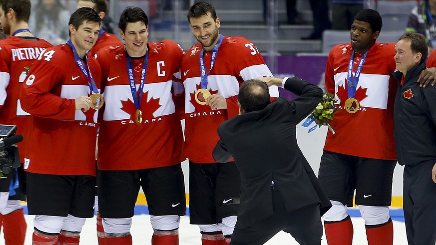 From left, Canada forward Chris Kunitz, forward Sidney Crosby and forward Patrice Bergeron pose with their gold medals for a team photographer after beating Sweden 3-0 in the men&#039;s gold medal ice ...