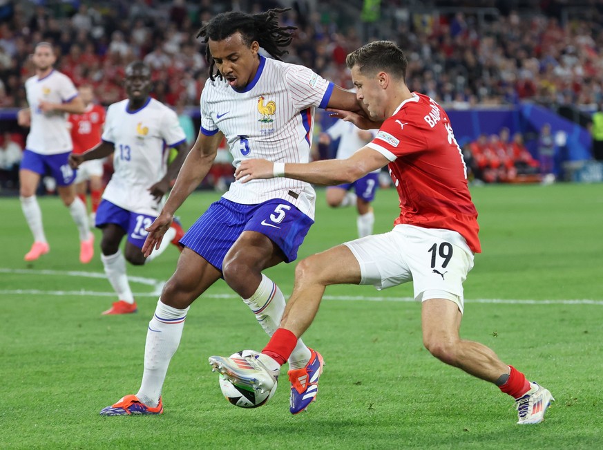 epa11418886 Jules Kounde (L) of France in action against Christoph Baumgartner (R) of Austria during the UEFA EURO 2024 group D soccer match between Austria and France, in Dusseldorf, Germany, 17 June ...