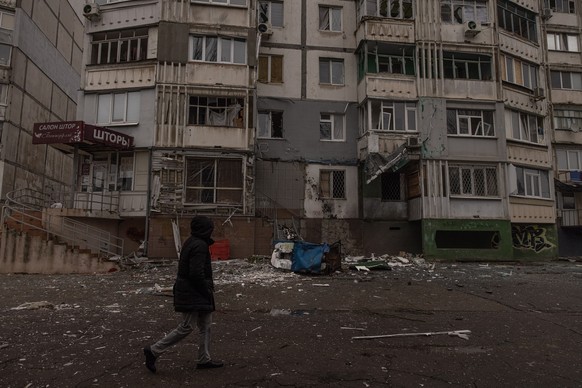 epa10328872 A man walks past a damaged residential building after the recent Russian attack in Kherson, southern Ukraine, 25 November 2022. Russian troops for the past few days intensified the shellin ...