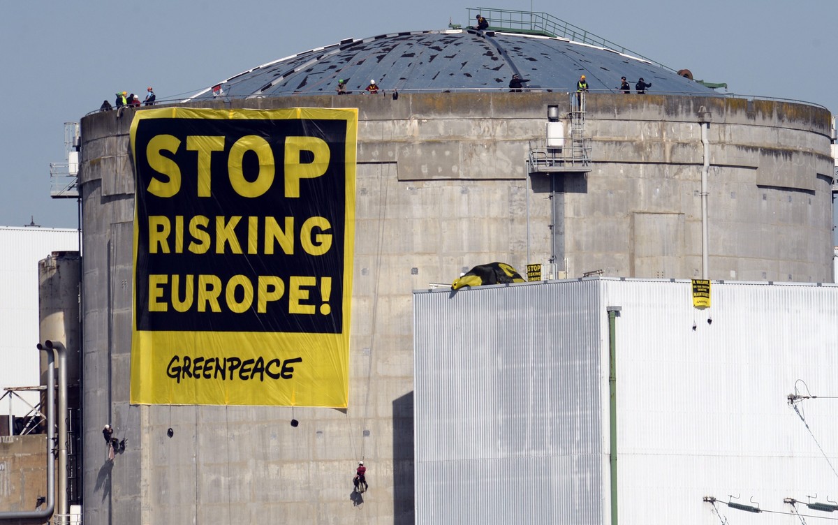 epa04130684 A protest banner from Greenpeace with text reading 'Stop Risking Europe!' is seen at the Fessenheim nuclear power plant in Fessenheim, France, 18 March 2014. An estimated 50 acti ...