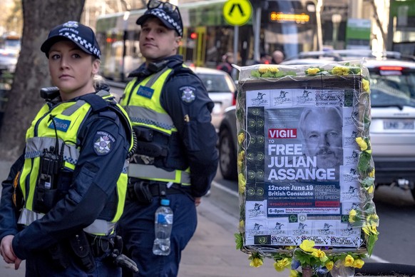 epa06820128 Police mmonitor protesters as they gather to show their support for Julian Assange during a protest outside the British consulate in Melbourne, Australia, 19 June 2018. Assange has been ho ...