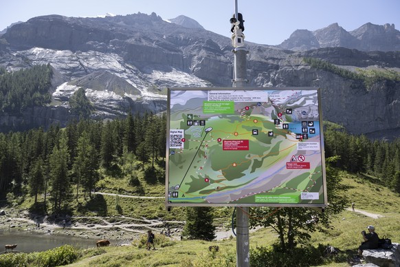 Eine Informationstafel vor der die instabilen Flanke des Spitze Stei, fotografiert oberhalb vom Oeschinensee bei Kandersteg, am Samstag, 9. August 2025. Das Dorf Kandersteg ist durch einen moeglichen  ...