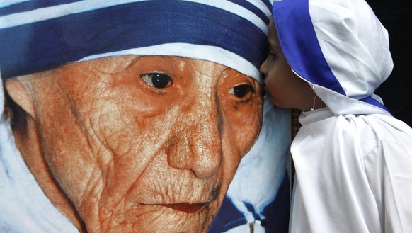 epa02301312 An Indian child dressed as Mother Teresa kisses her portrait during a tribute paying ceremony during the centenary birth celebrations of the mother in Bhopal, India, 26 August 2010. Mother ...