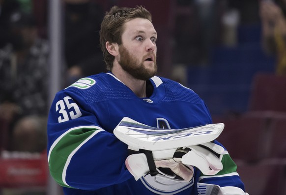 Vancouver Canucks goalie Thatcher Demko reacts after using smelling salts as he skates to his net before an NHL hockey game against the Carolina Hurricanes Sunday, Dec. 12, 2021 in Vancouver, British  ...