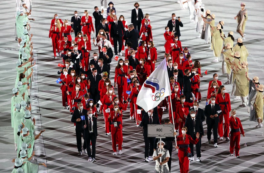 epa09360370 ....Flag Bearers of the Russian Olympic Committee (ROC) team Sofya Velikaya and Maxim Mikhaylov lead a delegation during the Opening Ceremony of the Tokyo 2020 Olympic Games at the Olympic ...