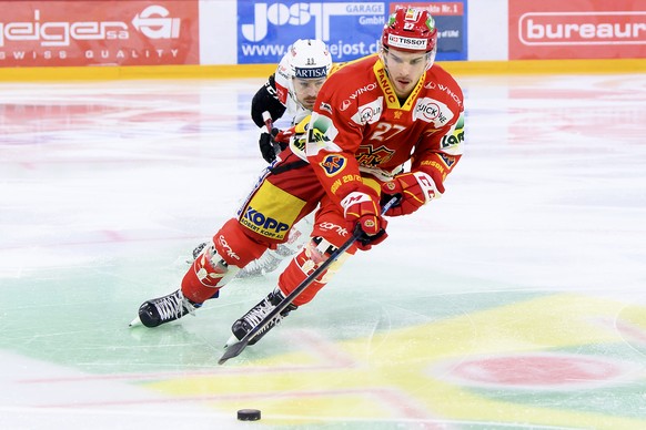 Luganos Mikkel Bodker, links, und Biels Yannick Rathgeb, rechts, kaempfen um den Puck, beim Eishockey Meisterschaftsspiel der National League zwischen dem EHC Biel und den HC Lugano, am Freitag, 18. D ...