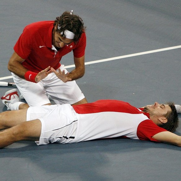 Roger Federer, left, and Stanislas Wawrinka of Switzerland react after winning their match against Bob Bryan and Mike Bryan during the semi final of the men&#039;s double tennis at the Beijing 2008 Ol ...