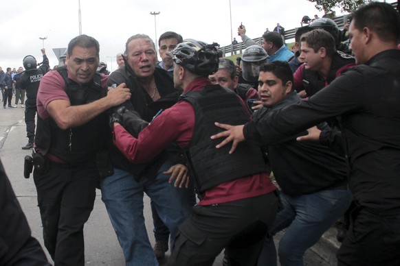 Sergio Berni, the security minister for the Buenos Aires province, center, is extracted from a protest in Buenos Aires, Monday, April 3, 2023. Berni was attacked during a protest by bus drivers after  ...