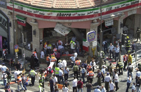 EDS NOTE GRAPHIC CONTENT - Police and medics surround the scene of a bomb explosion in a restaurant downtown Jerusalem Thursday, August 9, 2001. A bomb exploded in the pizza restaurant Sbarro at lunch ...