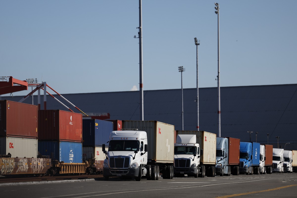 epa12456525 Trucks wait by stacks of shipping containers at the Port of Los Angeles in Los Angeles, California, USA, 15 October 2025. The US and China began charging additional port fees on 15 October ...