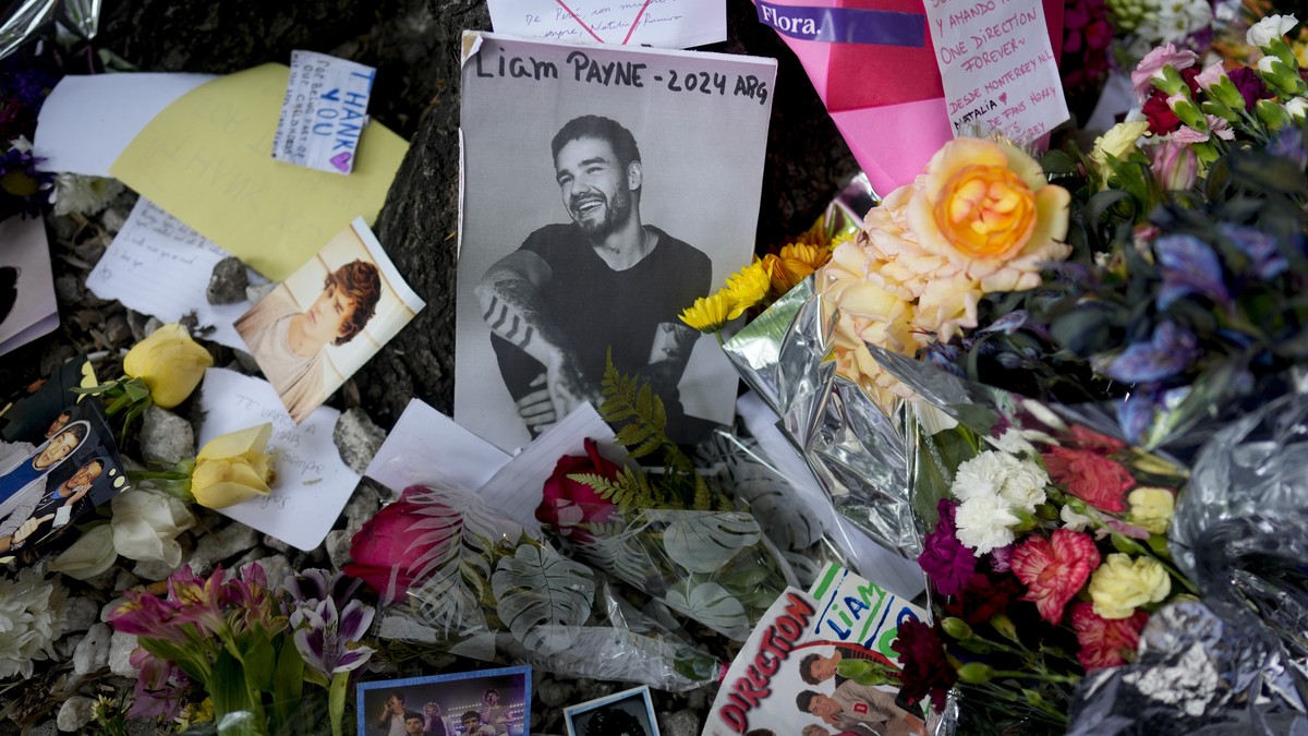 FILE - A picture of former One Direction singer Liam Payne sits surrounded by flowers and candles as fans gather outside the hotel where he was found dead after falling from a balcony in Buenos Aires, ...