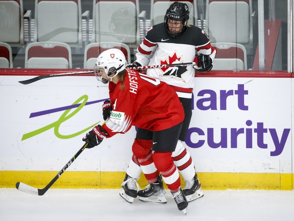 Switzerland&#039;s Nadine Hofstetter, left, checks Canada&#039;s Laura Stacey during the second period of an IIHF women&#039;s world hockey championships game in Calgary, Alberta, Tuesday, Aug. 24, 20 ...