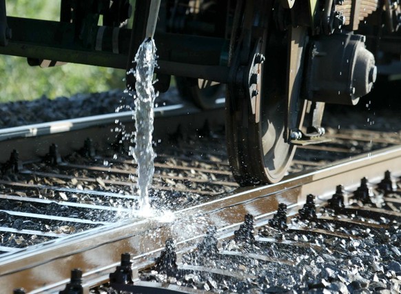 THEMENBILD ZUM MK DER SBB ZUR ANSTEHENDEN HITZEWELLE --- Ein Wagen der SBB kuehlt am Dienstag, 5. August 2003 auf der SBB-Linie Luzern-Zuerich bei Rotkreuz das einspurige Bahngleis mit kuehlendem Wass ...