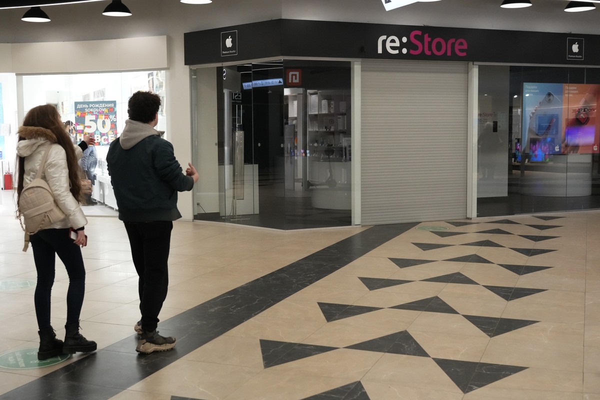 People look at a closed 're:Store', an Apple reseller shop at a shopping mall in St. Petersburg, Russia, Wednesday, March 2, 2022. Apple on Tuesday announced halting the sales of its iPhone  ...