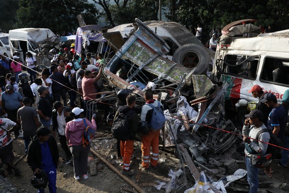 People gather around vehicles damaged in an attack on the Pan-American Highway in Cajibio, Colombia, Saturday, April 25, 2026, that killed at least a dozen people and authorities blamed on dissident g ...