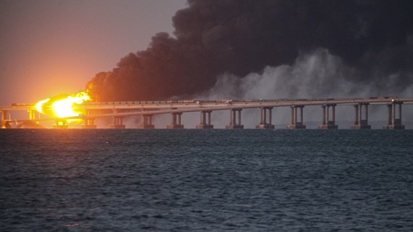 FILE - Flames and smoke rise from the Crimean Bridge connecting the Russian mainland and the Crimean peninsula across the Kerch Strait, in Kerch, Crimea, October 2018. 8, 2022. Russian authorities say a truck bomb...