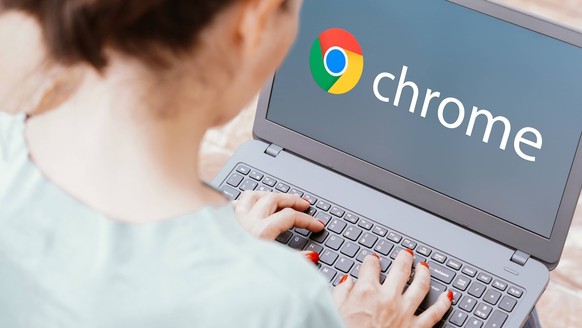 Frau vor Laptop mit Logo von Google Chrome.