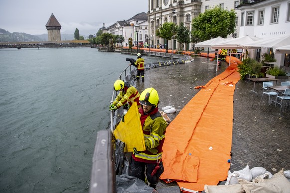 Die Feuerwehr der Stadt Luzern sichert die Bahnhofstrasse entlang der Reuss mit Schutzschlaeuchen aufgrund der angekuendigten Regenfaelle der naechsten Tage, am Dienstag, 13. Juli 2021, in Luzern. Der ...