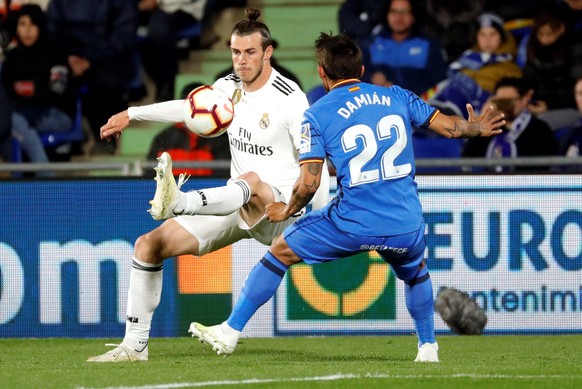epa07528446 Real Madrid's Gareth Bale (L) in action against Getafe CF's Damián Suarez (R) during a Spanish LaLiga soccer match between Real Madrid and Getafe at the Alfonso Perez Coliseum in Madrid, S ...
