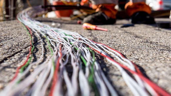 Ein Arbeiter montiert Glasfaserkabel der Swisscom fuer den Internetansschluss von Privathaushalten, am Dienstag, 10. Februar 2015 in Bellinzona. Die staedtischen Betriebe Bellinzona &quot;Aziende Muni ...