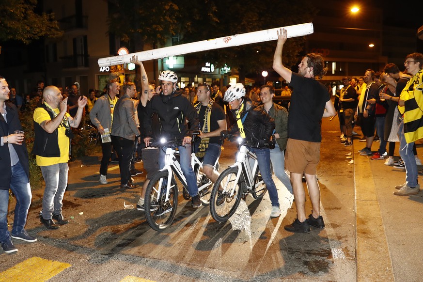 Radfahrer fahren unter dem mitgenommenen Torpfosten aus dem Stade de Suisse durch, waehrend die Fans den Meistertitel feiern, auf dem Breitenrainplatz nach dem Super League Spiel zwischen dem BSC Youn ...