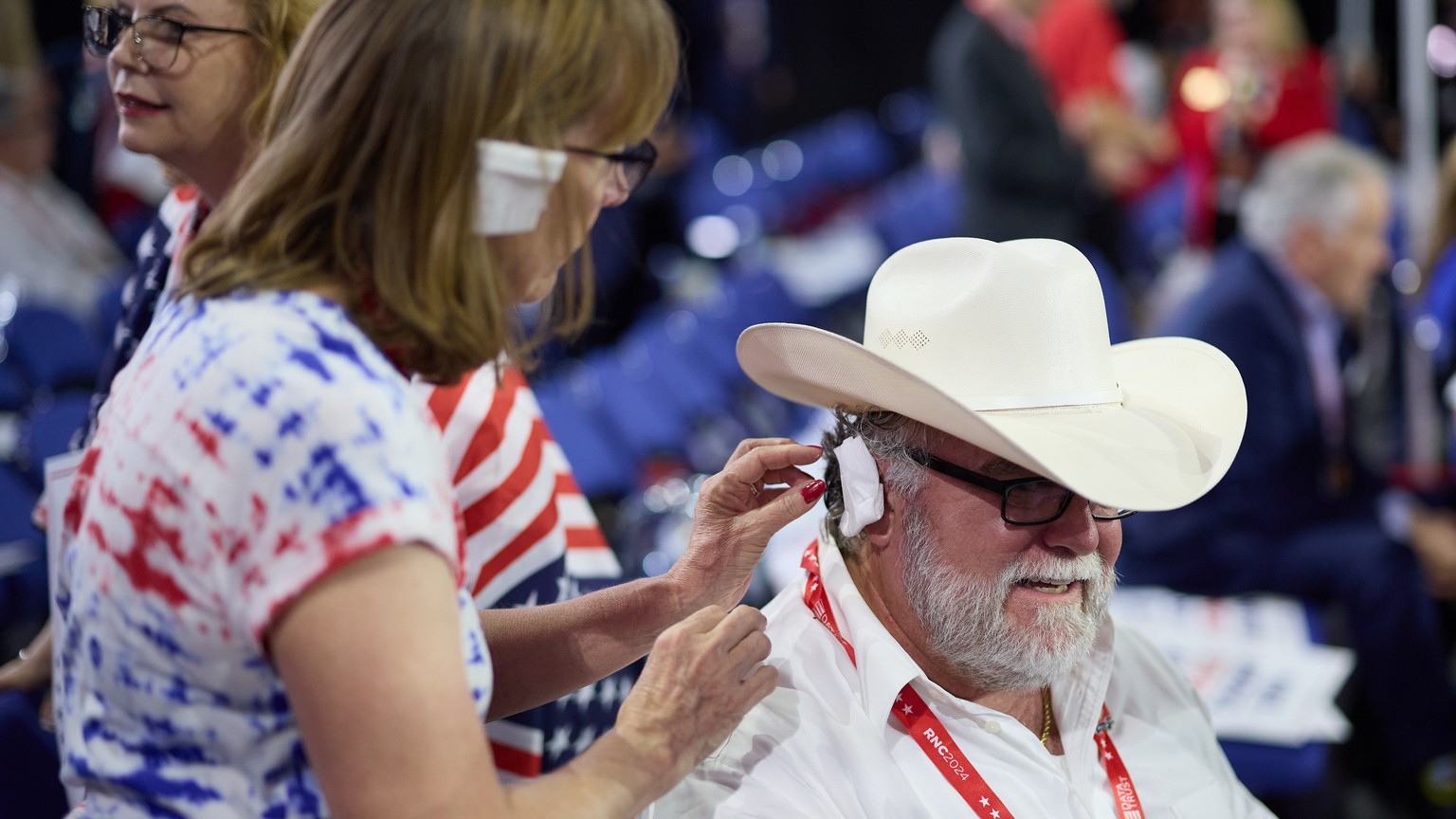 epa11484369 Supporters wear ear bandages in solidarity with Republican presidential nominee and former President Donald J. Trump during the third day of the Republican National Convention (RNC) at Fis ...