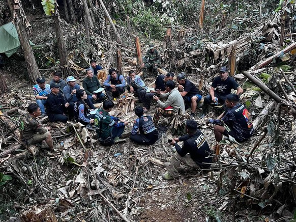 In this image released by Metta Tham Rescue Kalasin, rescuers gather, trying to reach people who have been trapped in a cave in Xaisomboun province, Laos, Tuesday, May 26, 2026. (Metta Tham Rescue Kal ...