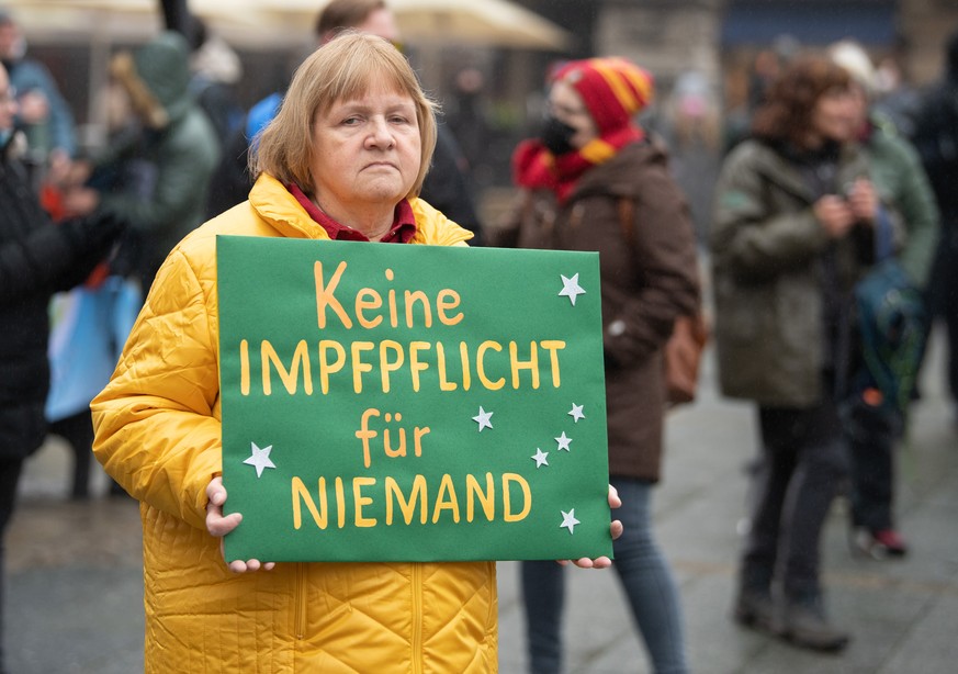 04.12.2021, Hessen, Frankfurt/Main: Eine Teilnehmerin einer Demonstration gegen Corona-Regelungen tr�gt ein Plakat mit der Aufschrift &quot;Keine Impfpflicht f�r Niemand&quot;. Mehrere hundert Teilneh ...