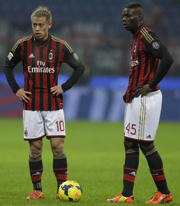 AC Milan forward Keisuke Honda of Japan, left, is flanked by his teammate AC Milan forward Mario Balotelli during a Serie A soccer match between AC Milan and Hellas verona, at the San Siro stadium in  ...