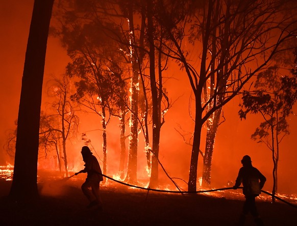 Australische Feuerwehrleute kämpfen gegen die Flammen zahlreicher Buschbrände. Nun steht ein junger Feuerwehrmann unter dem Verdacht, Feuer gelegt zu haben. (Foto: Dean Lewins/EPA Keystone)
