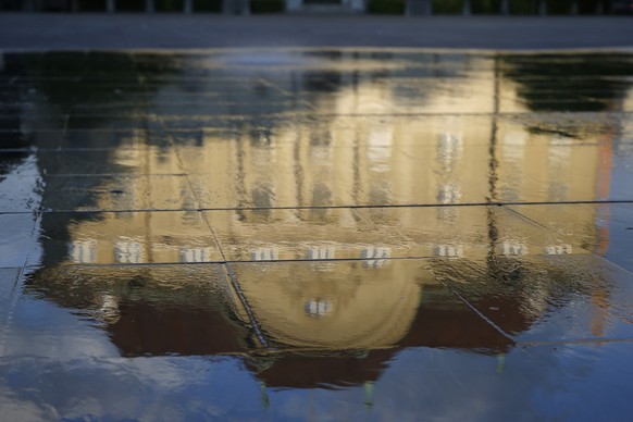 Währungsoffensive aus Bern – die Gebäudefront der Schweizer Nationalbank (SNB) spiegelt sich im Wasser des Brunnens auf dem Bundesplatz.