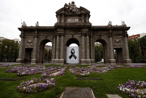 epa08378712 A black ribbon is displayed at at the Puerta de Alcala monument in memory of coronavirus fatalities, in downtown Madrid, Spain, 23 April 2020. Local authorities observed a minute silence f ...