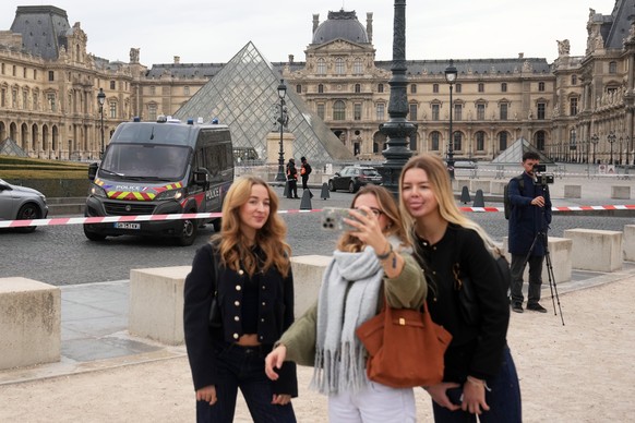 Tourists make a selfie in the courtyard of the closed Louvre museum after a robbery Sunday, Oct. 19, 2025 in Paris. (AP Photo/Thibault Camus)
France Louvre