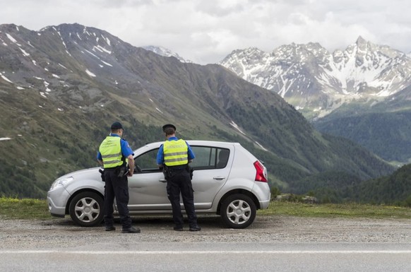 Grenzwächter kontrollieren ein Auto auf dem Berninapass.
