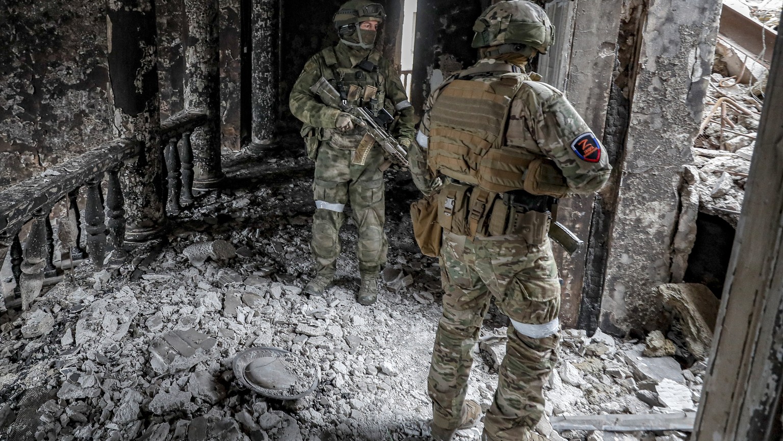 epa09886357 A picture taken during a visit to Mariupol organized by the Russian military shows a Russian serviceman securing the area inside the destroyed Drama Theatre in Mariupol, Ukraine, 12 April  ...